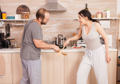 Young couple standing against wall at home