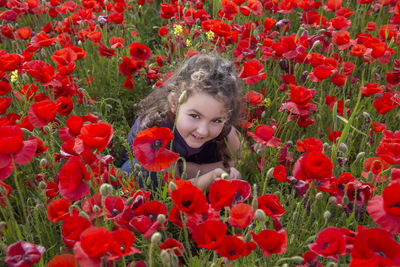 Portrait of smiling girl with red poppy flowers