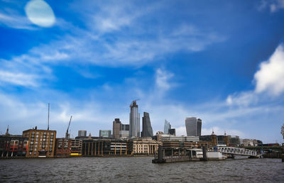 River and buildings against sky in city