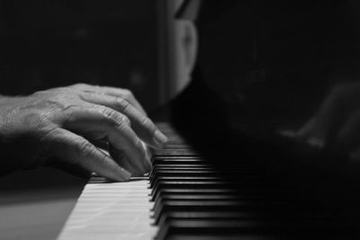 Cropped hands of man playing piano