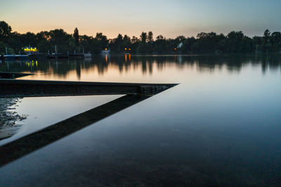 Scenic view of lake against sky at sunset