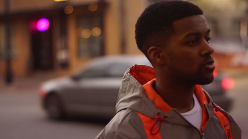 Portrait of young man looking away in city