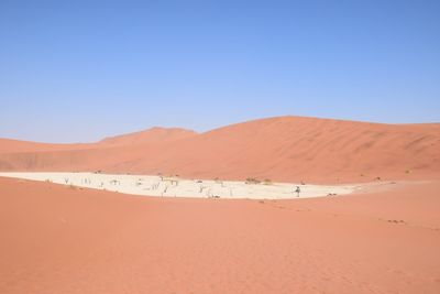 Scenic view of desert against clear blue sky