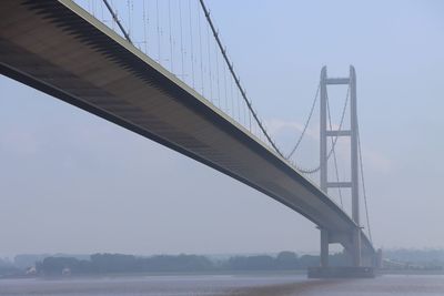 Low angle view of suspension bridge against sky