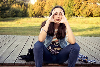 Portrait of young woman sitting on bench