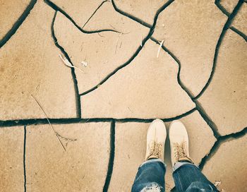 Low section of man standing on barren field