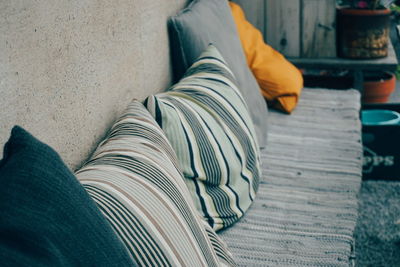 High angle view of pillows on seat by wall