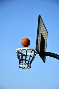 Low angle view of basketball hoop against clear blue sky