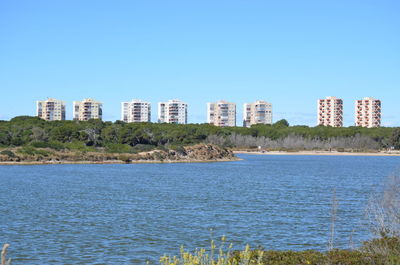 View of buildings against clear blue sky