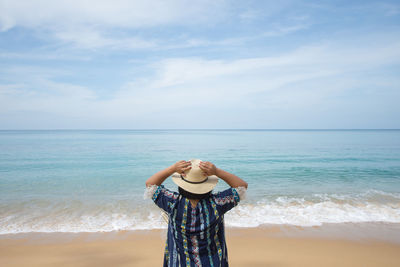 Man standing at beach against sky