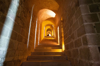 Low angle view of illuminated steps in old building