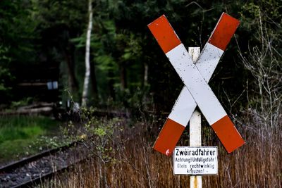 Railroad crossing sign against trees