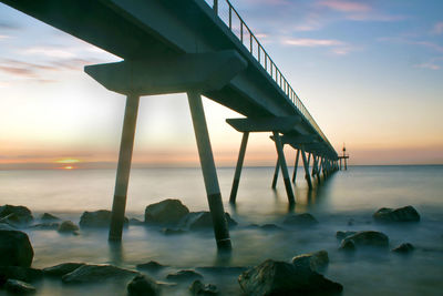 Close-up of beach against sky during sunset