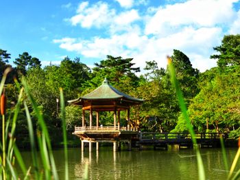 Gazebo by lake against sky