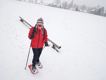 Single snow walker or cross skier sports woman and gray milky clouds in sky. powder snow falling