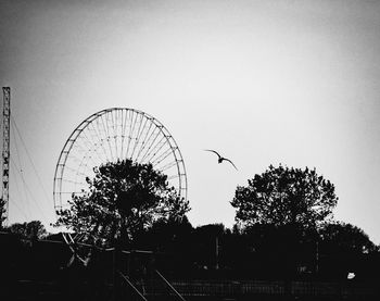 Silhouette ferris wheel against clear sky