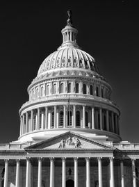 Low angle symmetric view of the u.s. capitol building against sky in black and white