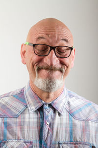 Mature man making face against gray background