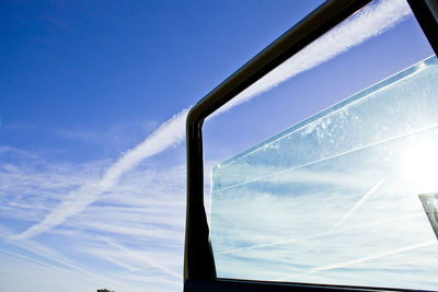 Low angle view of vapor trail against blue sky