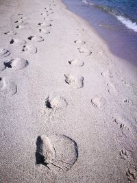 High angle view of footprints on sand at beach