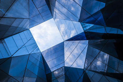 Low angle view of glass building against sky