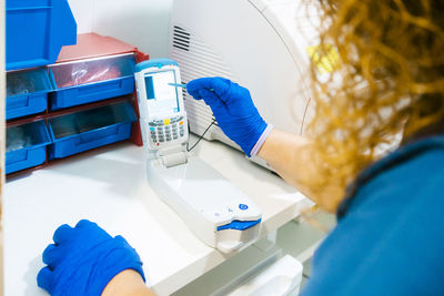 Nurse analyzing blood sample with equipment in laboratory