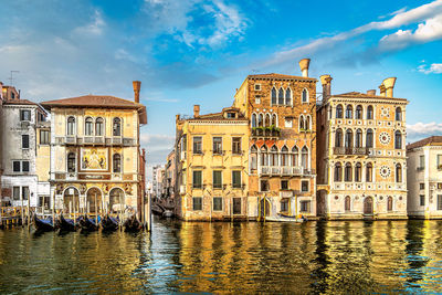 Buildings by river against sky