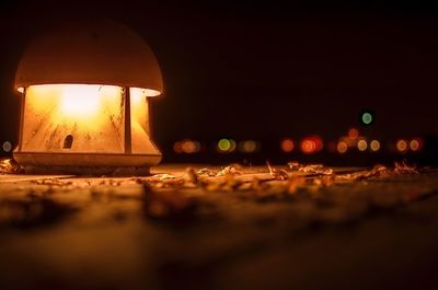 Close-up of illuminated lamp against sky at night