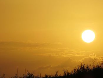 Scenic view of silhouette landscape against orange sky