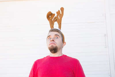 Portrait of young man standing against wall