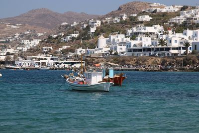 Boat moored on sea by town