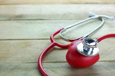 High angle view of heart shape and stethoscope on wooden table