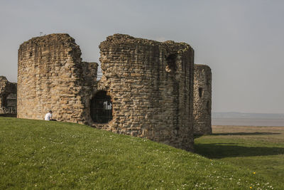 Old ruin building on field against clear sky, flint castle 