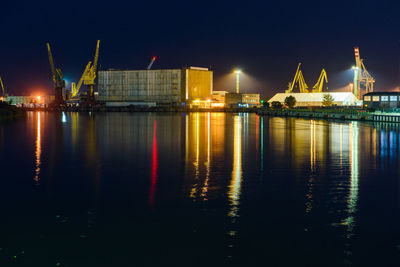 Illuminated pier at harbor against sky at night