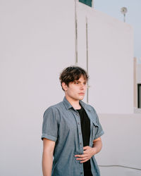 Portrait of a young man wearing a blue shirt witg wgite background 