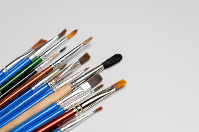 High angle view of make-up brushes over white background