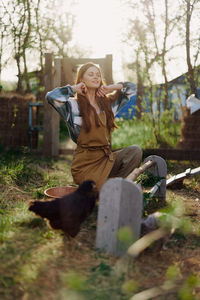 Side view of woman sitting on field