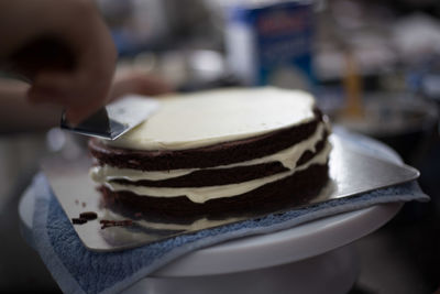 Cropped image of hand preparing cake at home