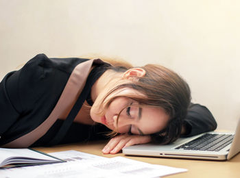 Close-up of young woman using smart phone on table