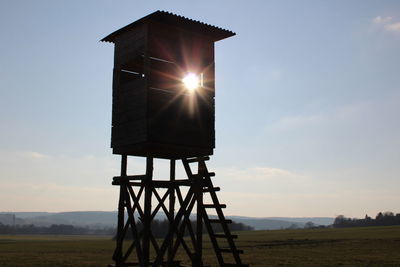 Lifeguard hut on field against sky during sunset