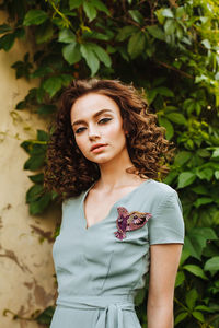 Portrait of young woman wearing make-up while standing against plants