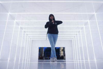 Young woman standing against wall