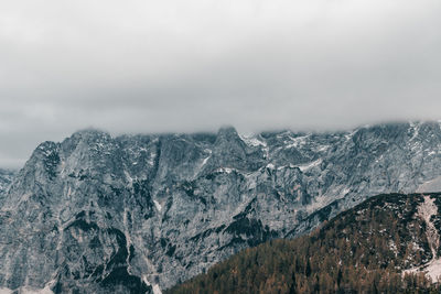 Layer of clouds covering rocky mountain peaks at vrsic mountain pass in julian alps in slovenia