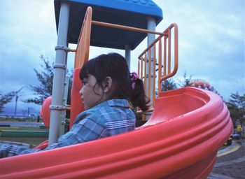 Portrait of boy on slide at playground