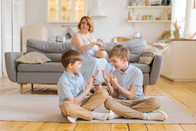 Happy family spend free time in living room, young parents are relaxing on sofa