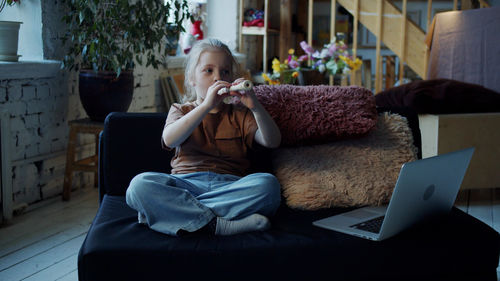 Cute girl playing flute at home