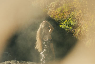 Portrait of young woman amidst trees