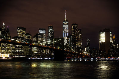 Illuminated buildings in city against sky at night