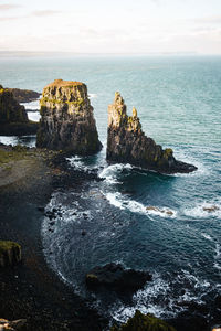 Scenic view of rocks in sea against sky