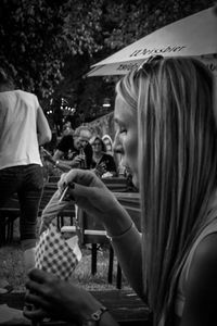 Side view of a young woman sitting on table